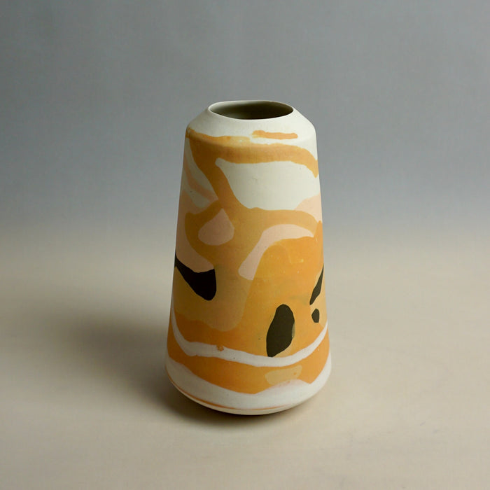 Cylindrical ceramic vase with abstract orange and white design on a gradient background. Dreamlands Vase | Anna Jones Ceramics | Shop Fodder