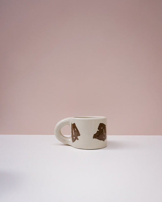 White mug with brown abstract designs on a light pink background. Portrait Mug | Brutes London | Handmade Ceramics | Fodder