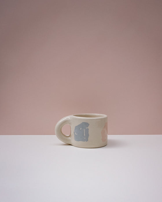 White mug with a blue design on a pink background. Portrait Mug | Brutes London | Handmade Ceramics | Fodder