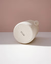 White cylindrical product with 'BRUTES' branding on a light pink background. Handmade Stoneware 500ml Carafe by BRUTES Ceramics | Shop Fodder