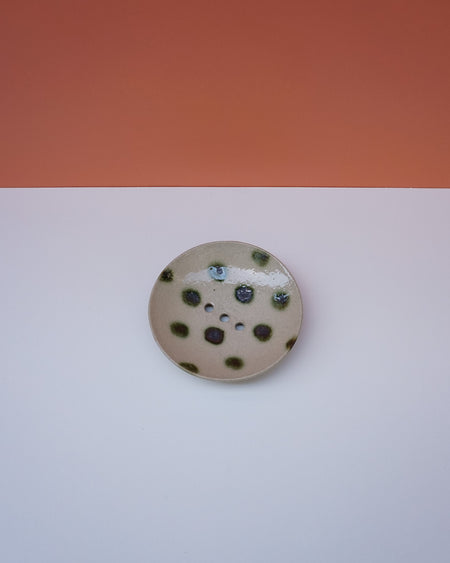 Round ceramic dish with black speckles on a white background. Cara Guthrie Ceramics. Fodder