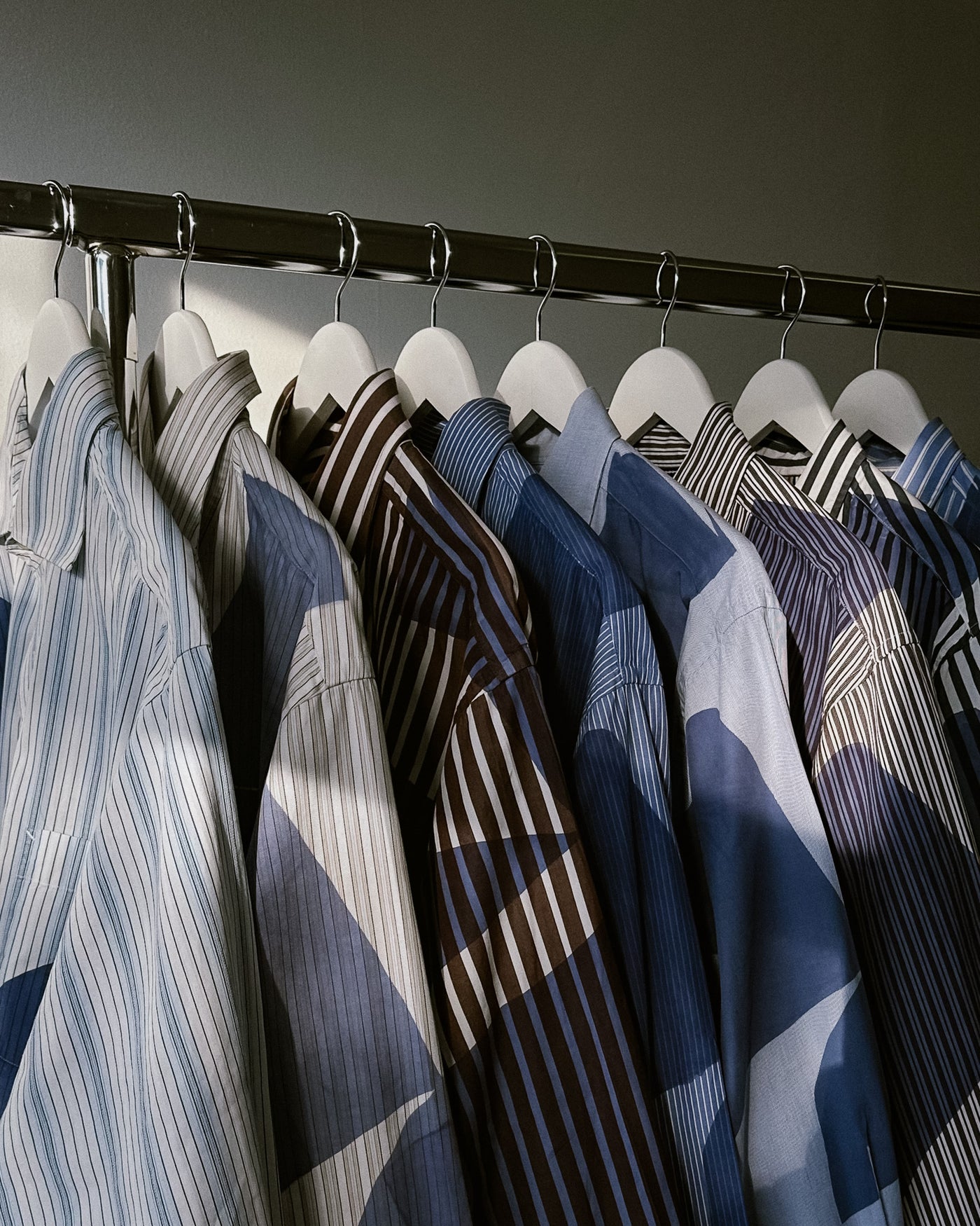 Collection of shirts on hangers with a neutral background | Caroline Dickinson | Shop Fodder