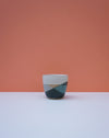 Ceramic cup with geometric design on a peach background. Liz Vidal Ceramics | Shop Fodder