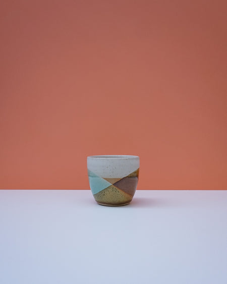 Ceramic cup with geometric design on a peach background. Liz Vidal Ceramics | Shop Fodder