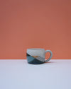Ceramic mug with geometric design on a peach and white background. Liz Vidal Ceramics | Shop Fodder