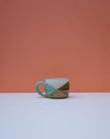 Ceramic mug with geometric design on a peach and white background. Liz Vidal Ceramics | Shop Fodder