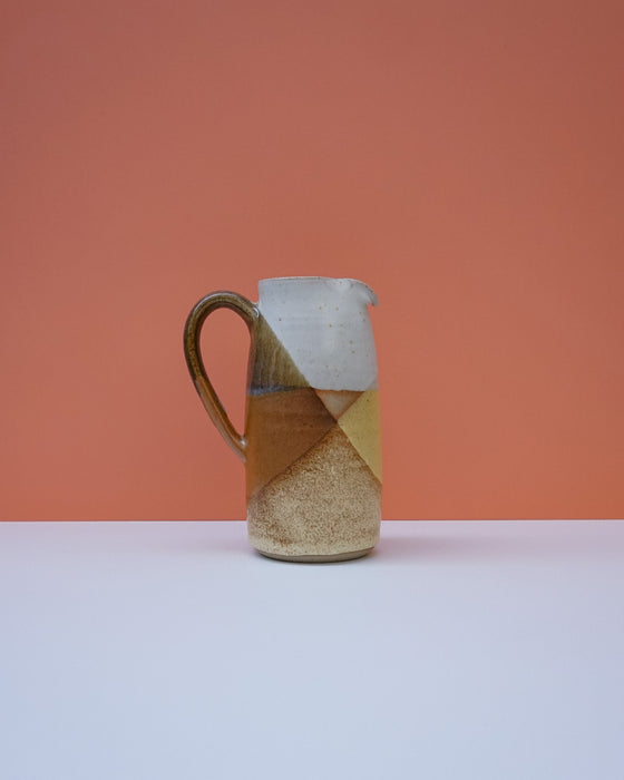 Ceramic pitcher with a geometric design on a peach background. Liz Vidal Ceramics | Shop Fodder