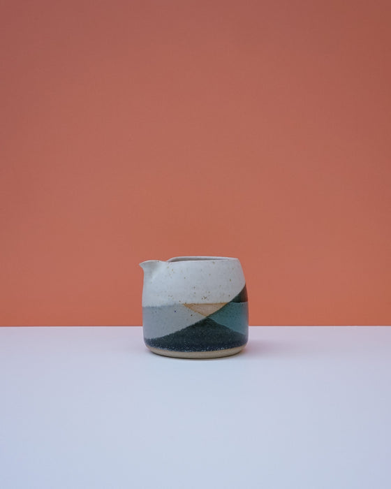 Ceramic pitcher with geometric design on a peach and white background. Liz Vidal Ceramics | Shop Fodder