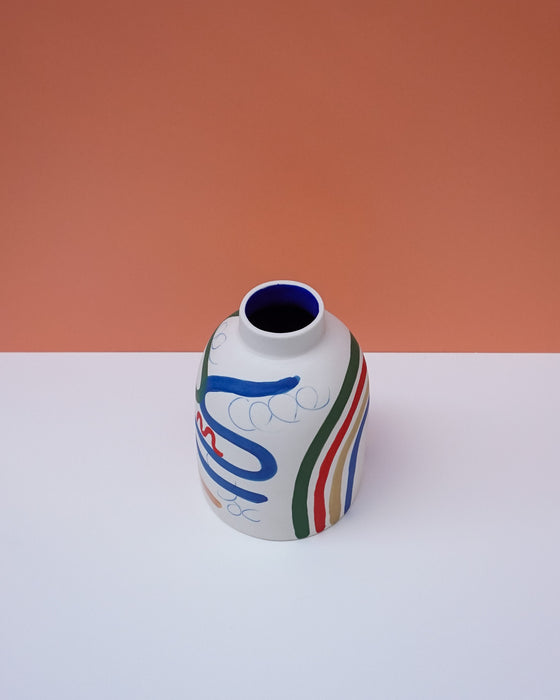 Ceramic vase with colorful abstract design on a white surface and orange background. Sophie Alda | Handmade Ceramics | Shop Fodder