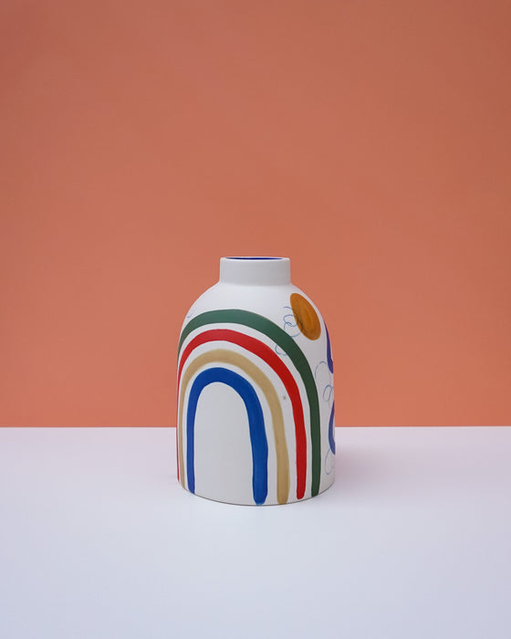Vase with colorful rainbow design on a peach background. Sophie Alda | Handmade Ceramics | Shop Fodder