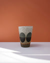 Ceramic cup with speckled pattern on a peach background. Sophie Alda | Handmade Ceramics | Shop Fodder