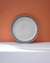 White ceramic plate with blue floral rim on an orange background. Sophie Alda | Handmade Ceramics | Shop Fodder