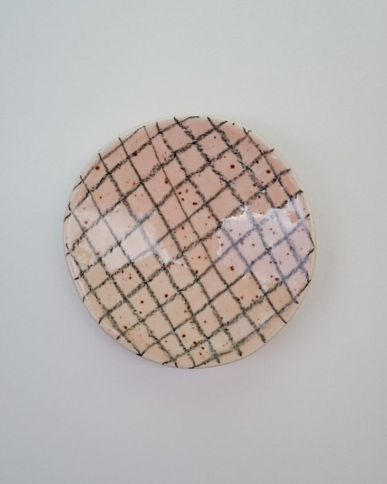 Round ceramic plate with grid pattern on a light gray background. Diddy Bowl | Jode Pankhurst | Shop Fodder