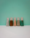 Five wooden blocks with different textures and colors on a teal background | Jode Pankhurst