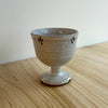 Ceramic goblet with speckled glaze on a wooden surface. Lily Pearmain Ceramics | Shop Fodder