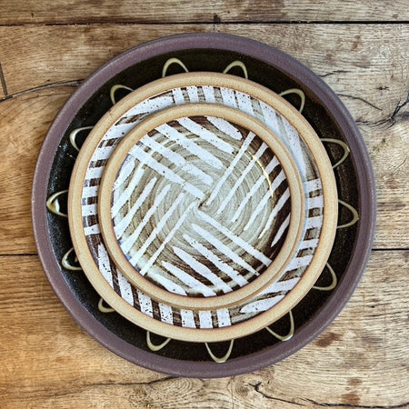 a stack of three plates on a wooden table taken from above. 