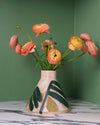 cone shaped vase with a leaf pattern and pinky yellow flowers on a marble table with a green background. Sophie Alda | Handmade Ceramics | Shop Fodder