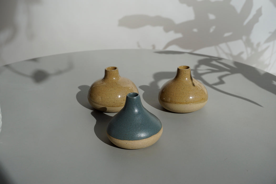 three Cara Guthrie bud vases sitting on a table. 