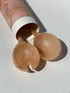 Two beige silicone cups with a white cylindrical container on a light gray background. Maegen | Shop Fodder