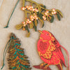 Decorative Christmas ornaments including a bird, tree, and mistletoe on a textured beige background.  | East End Press | Shop Fodder